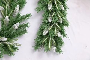 Close-up of frosted PE and PVC Christmas garland with realistic white snow on green needles