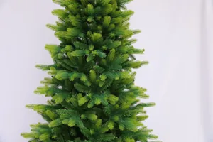 Close-up of dense PE and PVC pine branches on a lush green artificial Christmas tree