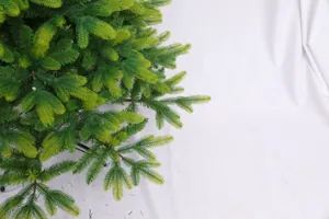 Close-up of realistic PE and PVC light green needles on a dense Christmas tree branch