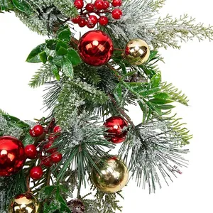 Couronne de Noël avec aiguilles de pin floquées, baies rouges et boules dorées sur fond blanc