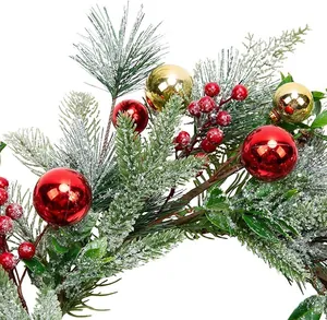 Gros plan d'aiguilles de pin givrées avec des baies rouges et des boules de Noël dorées