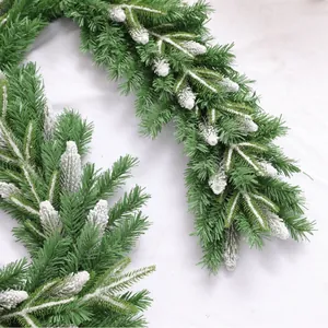 Frosted pine needle Christmas garland with dense green branches and thick artificial snow