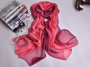 Detalle de una bufanda de seda con degradado de rosa a púrpura y un drapeado muy suave