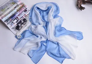 Detalle plano de una bufanda de seda con degradado azul y blanco y accesorios de moda