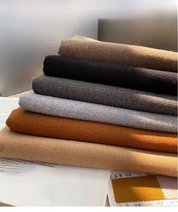 Detailed stack of thick cashmere-feel scarves in warm earthy tones and textures