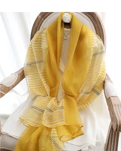 Detailed texture of ginger yellow silk wool shawl draped elegantly on a vintage chair