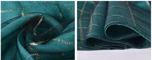 Detail of dark teal silk scarf with gold metallic grid pattern and sheer texture