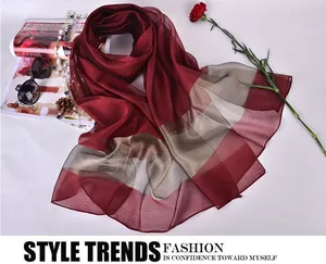 Detail view of burgundy and champagne silk scarf with soft fabric textures and folds