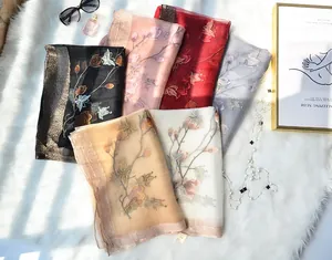 Close-up of silk scarves featuring delicate floral embroidery and gold glitter borders