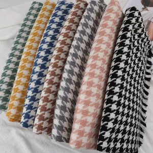 Close-up of houndstooth scarves in seven colors with elegant fringe details