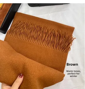 Detail shot of solid brown winter scarf with tassel fringe in soft cashmere-like fabric