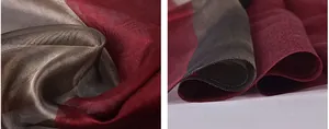 Close-up of wine red and champagne gold silk scarf with sheer texture and hemmed edge