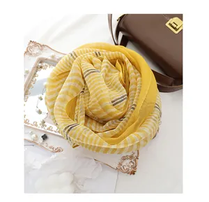 Detail of yellow checkered silk wool scarf with white stripes and light texture