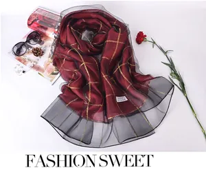 Detail of burgundy silk scarf with gold grid pattern and double-layered organza lace trim