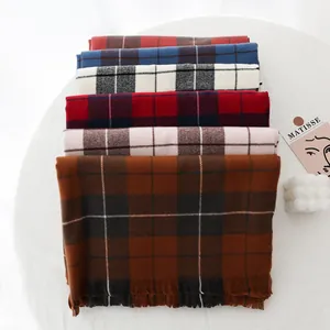 Multiple color options of plaid scarves with tassels in a stylish stacked arrangement
