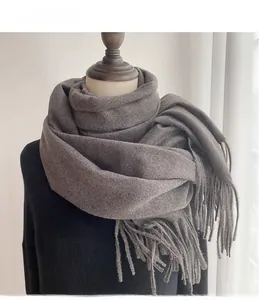 Close-up of thick dark grey cashmere-like scarf with fringe tassels on a mannequin