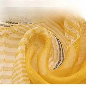 Close-up of lightweight silk wool shawl featuring yellow plaid stitching and sheer texture