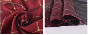 Detail of red and black gradient silk scarf with gold metallic grid texture and organza finish