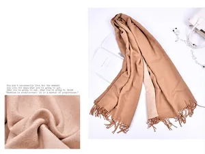 Dettaglio di sciarpa color cammello effetto cashmere con frange e morbida trama invernale