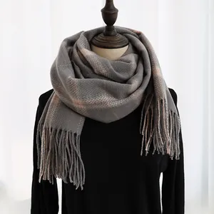 Close-up of grey houndstooth patterned scarf featuring soft fringe trim and thick cashmere feel