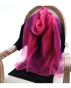 Détail de l'écharpe en soie et laine dégradé rose-violet posée sur une chaise vintage