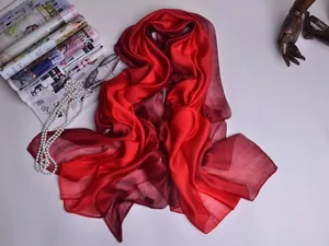 Primer plano de bufanda de seda ligera con degradado rojo y brillo suave natural
