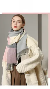 Detail of soft pink and grey checkered wool scarf with long tassel fringe on casual model