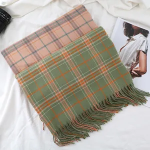 Detail of soft houndstooth cashmere scarves featuring fringe edges and autumn patterns
