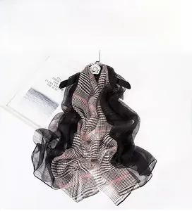 Detail view of 190x85cm silk wool blend scarf with plaid pattern and sheer texture
