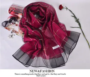 Detailed view of luxury 100% silk scarf in burgundy with gold checks and black mesh trim