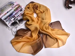 Detalle de un pañuelo de seda con degradado amarillo y marrón y accesorios de moda