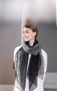 Detail of classic plaid and striped silk wool scarf with lightweight woven texture