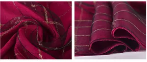Detail of burgundy silk scarf with gold metallic grid patterns and black sheer mesh edges
