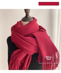 Close-up of thick wine red cashmere-like scarf with dense fringe tassels for winter warmth