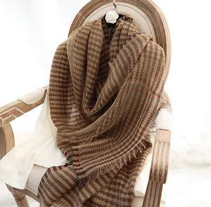 Detail of silk shawl with houndstooth pattern and fringe over vintage wooden chair