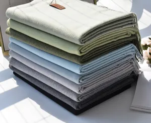 Detailed view of stacked multi-color cashmere-like scarves with fringe and soft texture