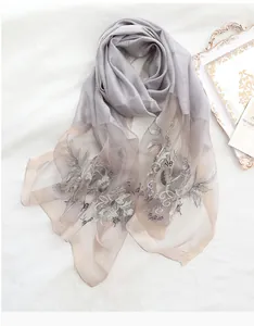 Detailed embroidery on light gray silk wool scarf with semi-transparent texture