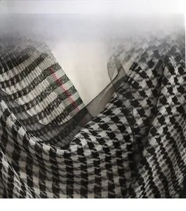 Detail of silk and wool scarf featuring classic black and white houndstooth pattern texture
