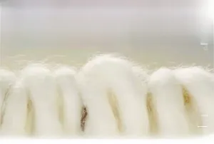 Macro shot of soft white wool fiber texture showing thick warm insulation detail