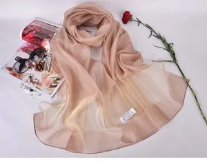 Detail of 100% silk champagne gold scarf with satin finish and luxury accessories