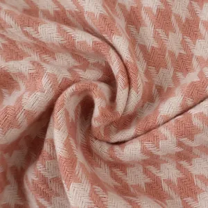 Detailed macro view of soft pink and white houndstooth fabric texture and fibers