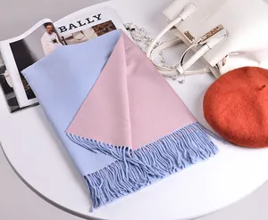 Vista piatta di una sciarpa in cashmere double-face blu e rosa con nappe e oggetti moda