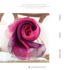 Détail d'une écharpe en soie dégradée drapée en forme de fleur sur une chaise blanche