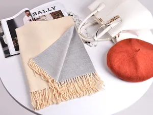 Dettaglio della sciarpa in cashmere double face beige e grigia con sottili frange