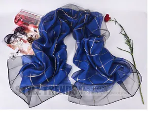 Detail of royal blue silk scarf with gold grid pattern and sheer black mesh edges