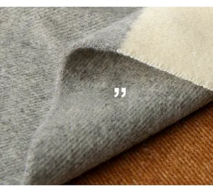 Close-up of grey and cream wool fabric showing soft texture and premium weave detail