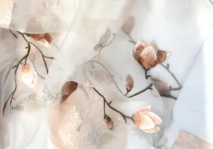 Close-up of elegant magnolia embroidery and butterfly on sheer silk scarf fabric