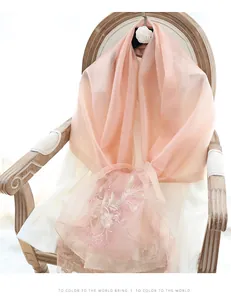 Detail of floral embroidery with gold threads on light pink silk wool pashmina shawl