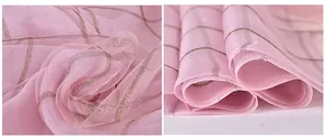 Detail of pink silk scarf showing transparent mesh texture with gold metallic grid threads