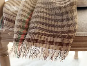 Close-up of classic striped wool scarf with long tassels on a vintage wooden chair